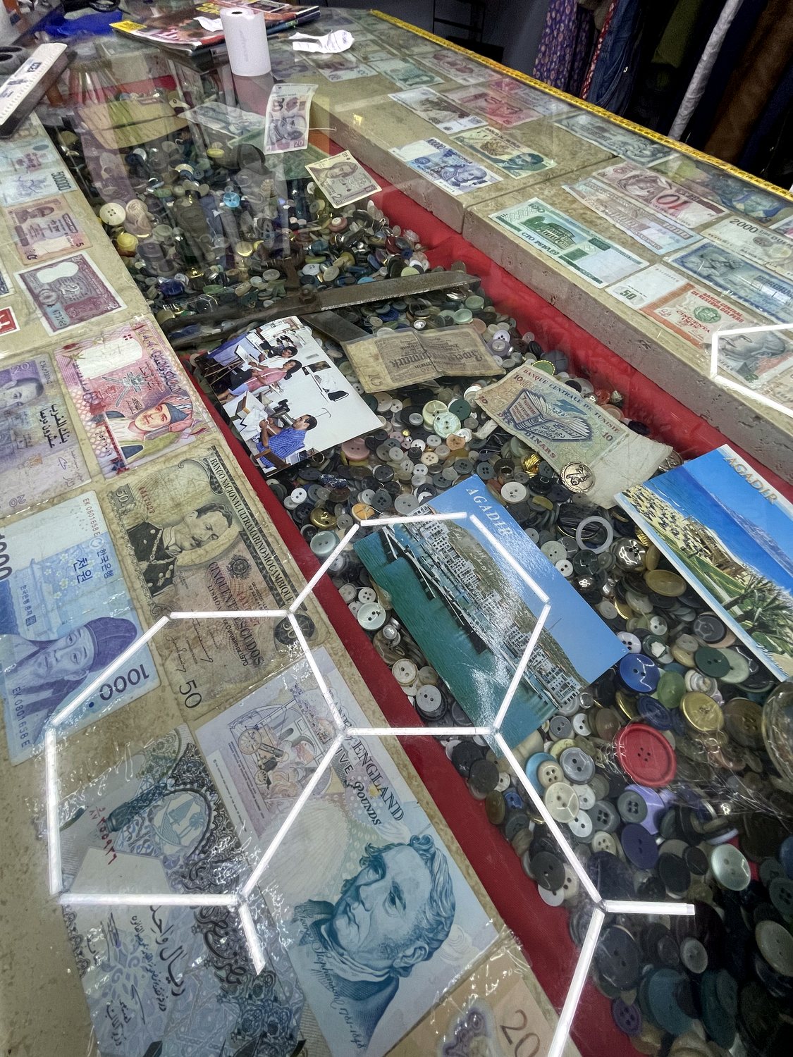 Banco storico del laboratorio con banconote, bottoni e ricordi sotto vetro